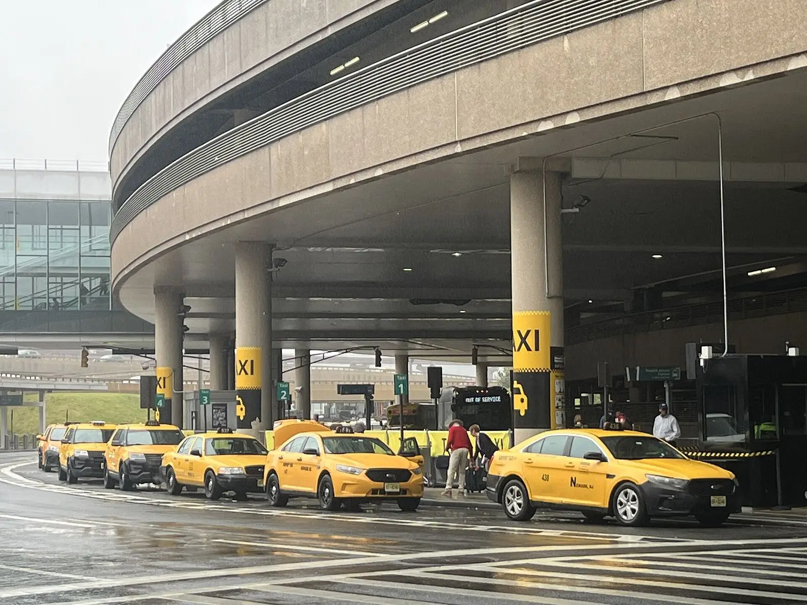 Yellow taxis lined up at a terminal curb at Newark Liberty International Airport