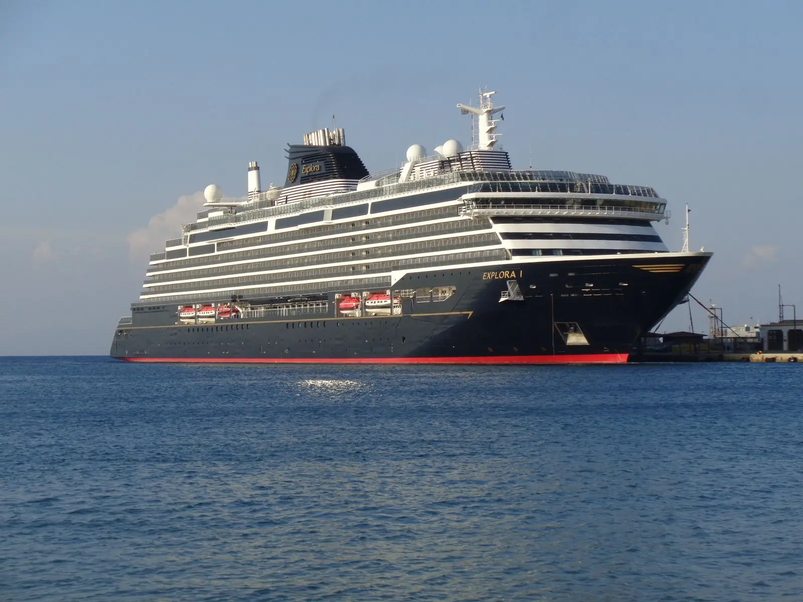 Explora I of Explora Journeys moored at the port of Rhodes in Greece in August 2024, with the ship's name on the bow