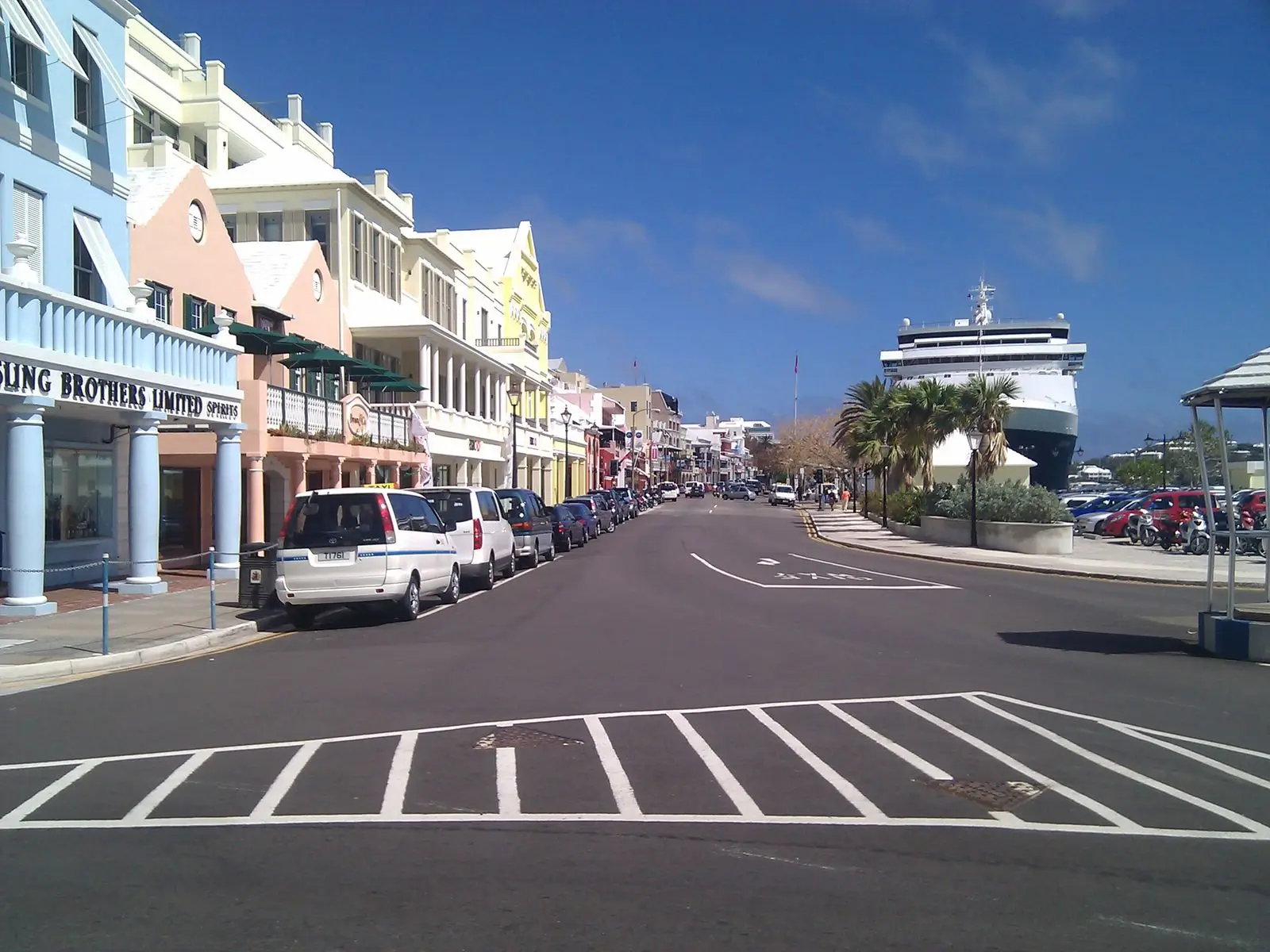 Front Street in Hamilton, Bermuda, with pastel buildings and a cruise ship at the end of the street