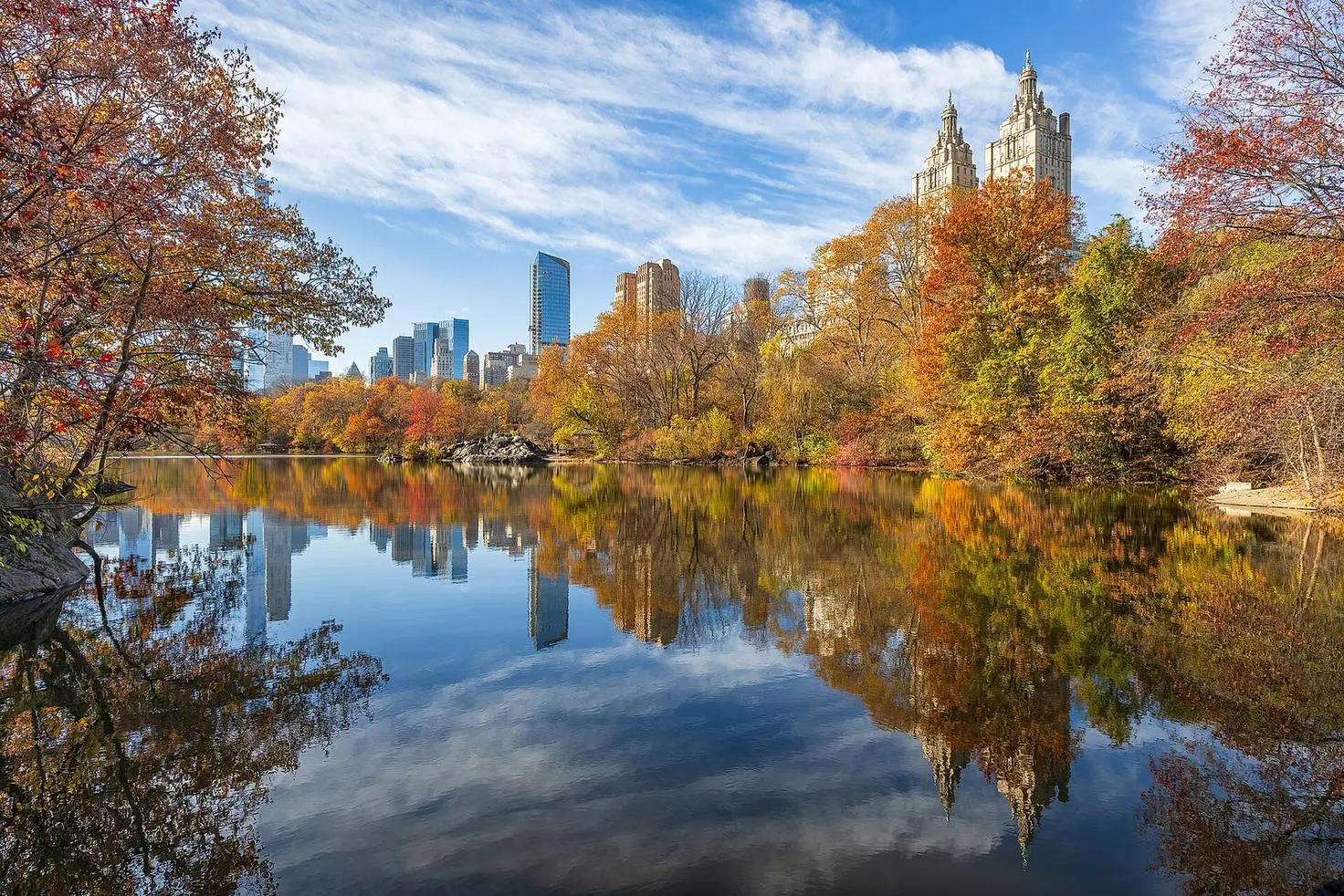 Autumn foliage and the Midtown skyline reflected in the lake in Central Park, New York