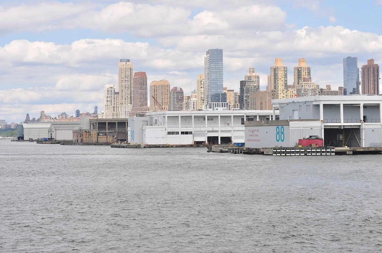 Pier 88 and the neighbouring piers on the Hudson River in Manhattan, seen from the water with the Midtown West skyline behind