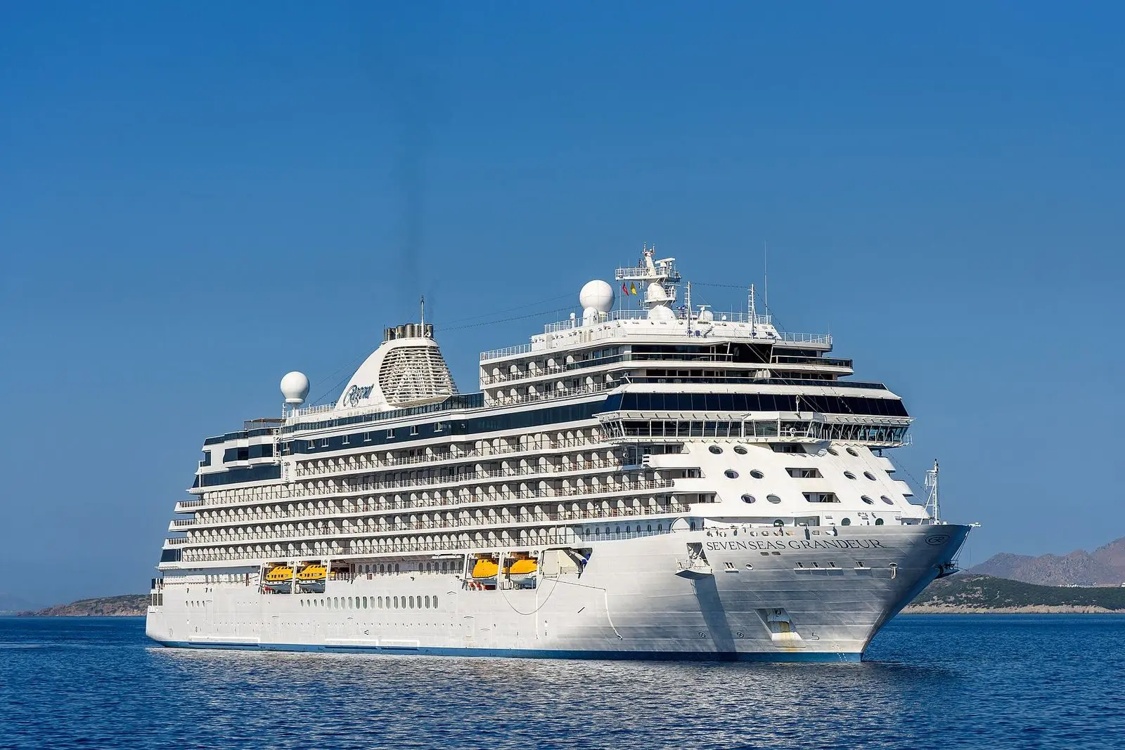 Seven Seas Grandeur under way on calm blue water in June 2024
